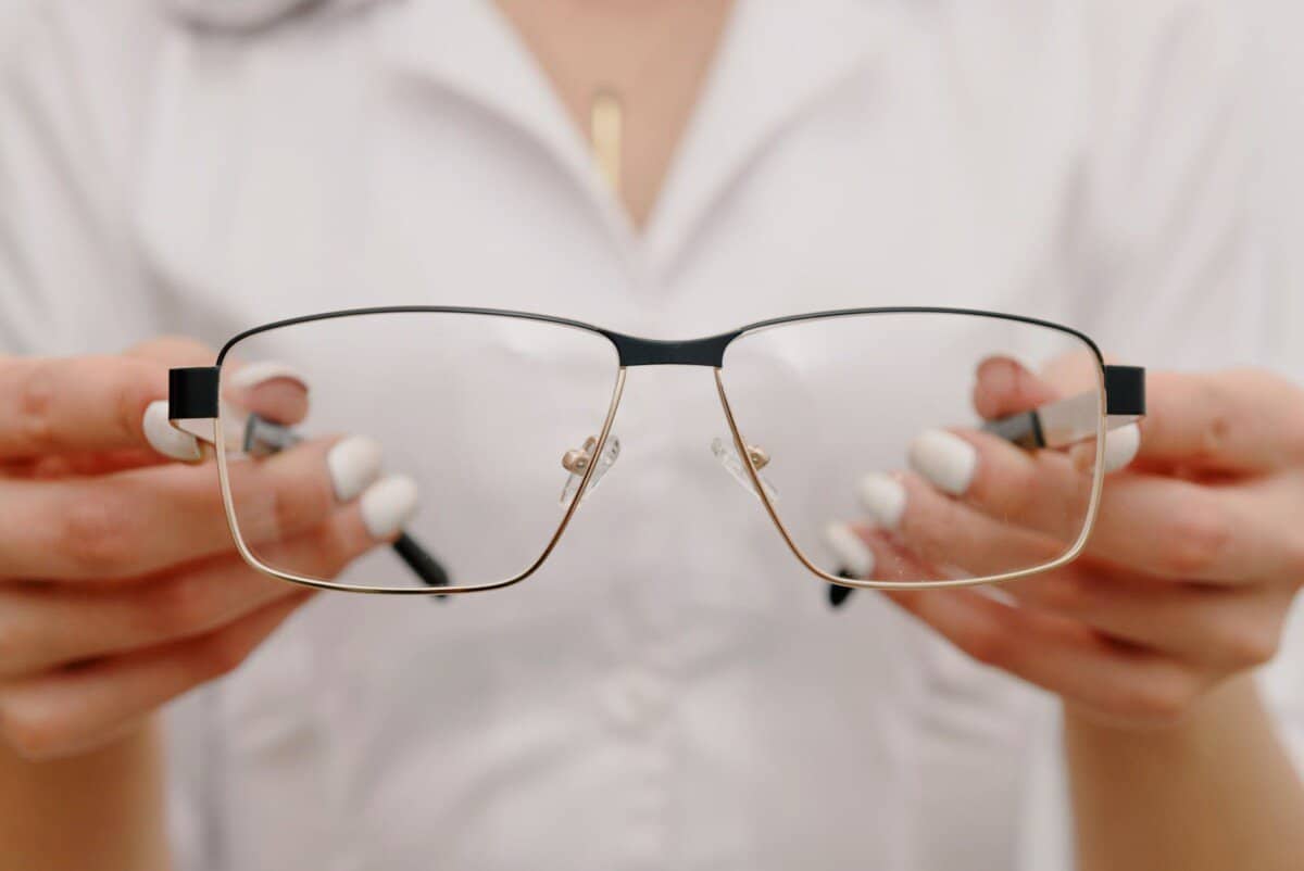crop unrecognizable female ophthalmologist showing eyeglasses